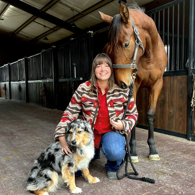 Abby, posing next to her horse and her Australian shepherd dog.